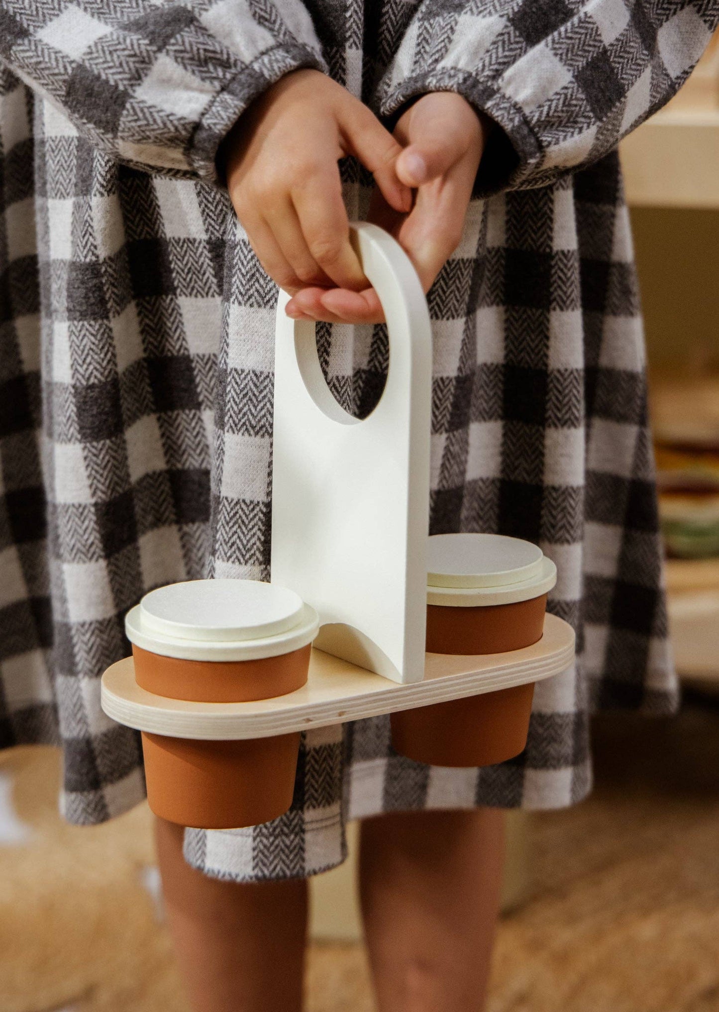 Close-up of wooden cup holder for easy transport of play coffee cups