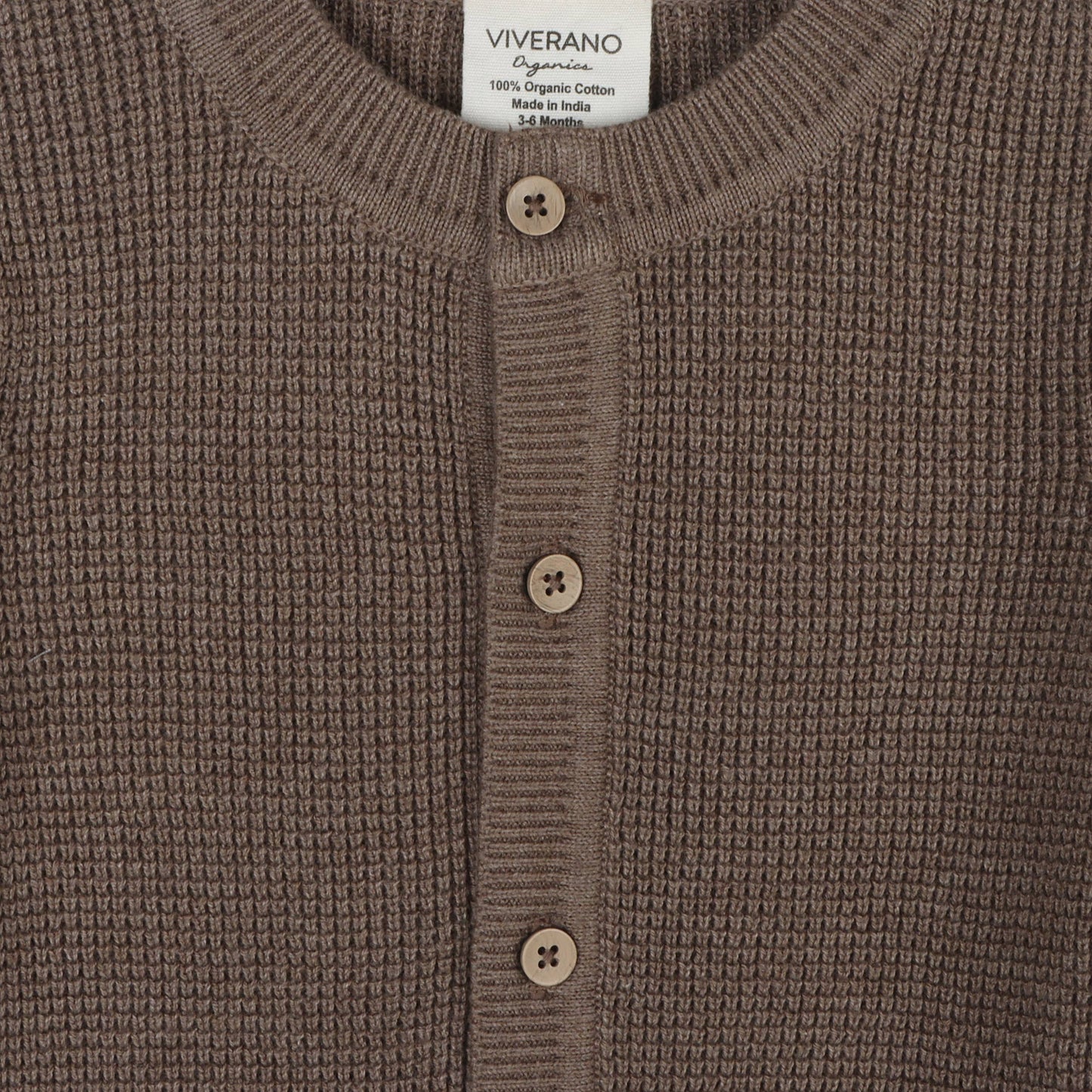 Close-up of the soft knit texture on the Long Sweater Romper with buttons and pockets by Viverano Organics. The cozy and breathable fabric is perfect for keeping little ones warm and comfortable. The carefully crafted design features functional buttons and stylish pockets, offering both practicality and charm. Made with organic materials, this romper is a beautiful, sustainable choice for babies, combining comfort and style effortlessly.