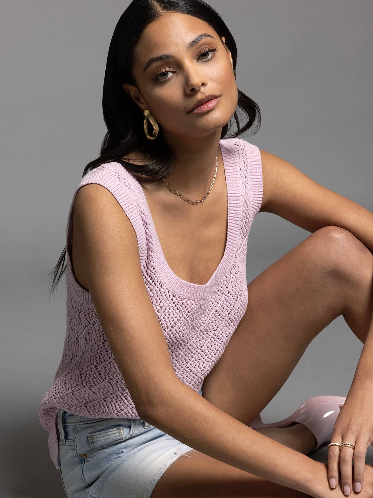 Model sitting in studio wearing Bailey Square Neck Knit Top in lilac paired with shorts, showing relaxed styling
