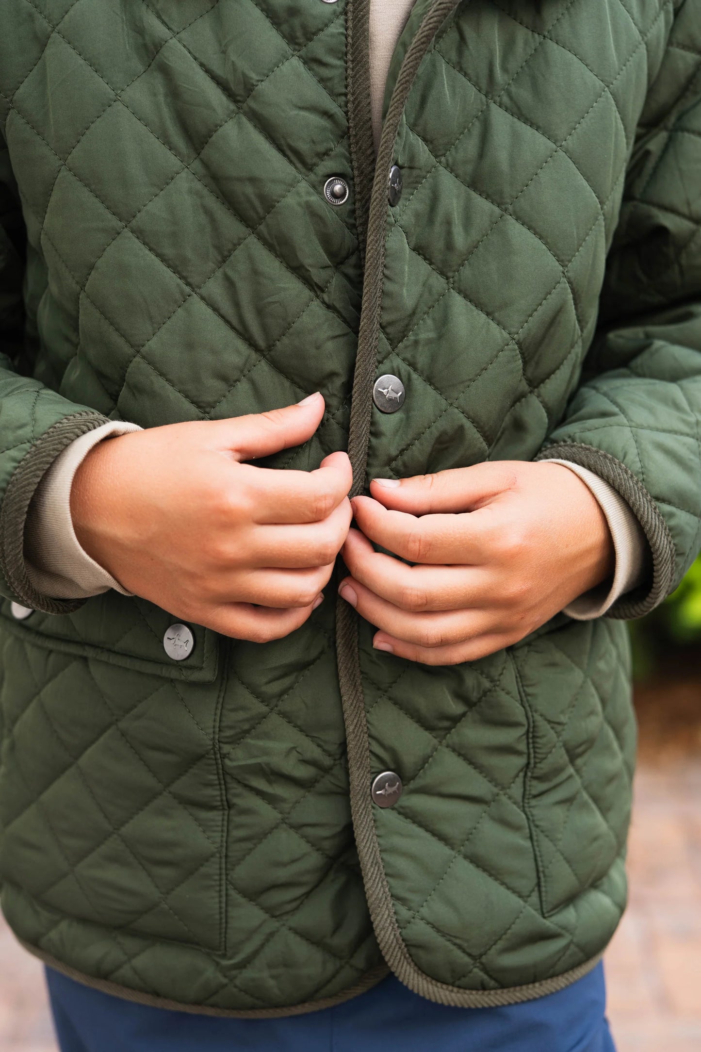 Close-up of button closure on Boys Derby Field Jacket in green, showing quality construction and attention to detail.