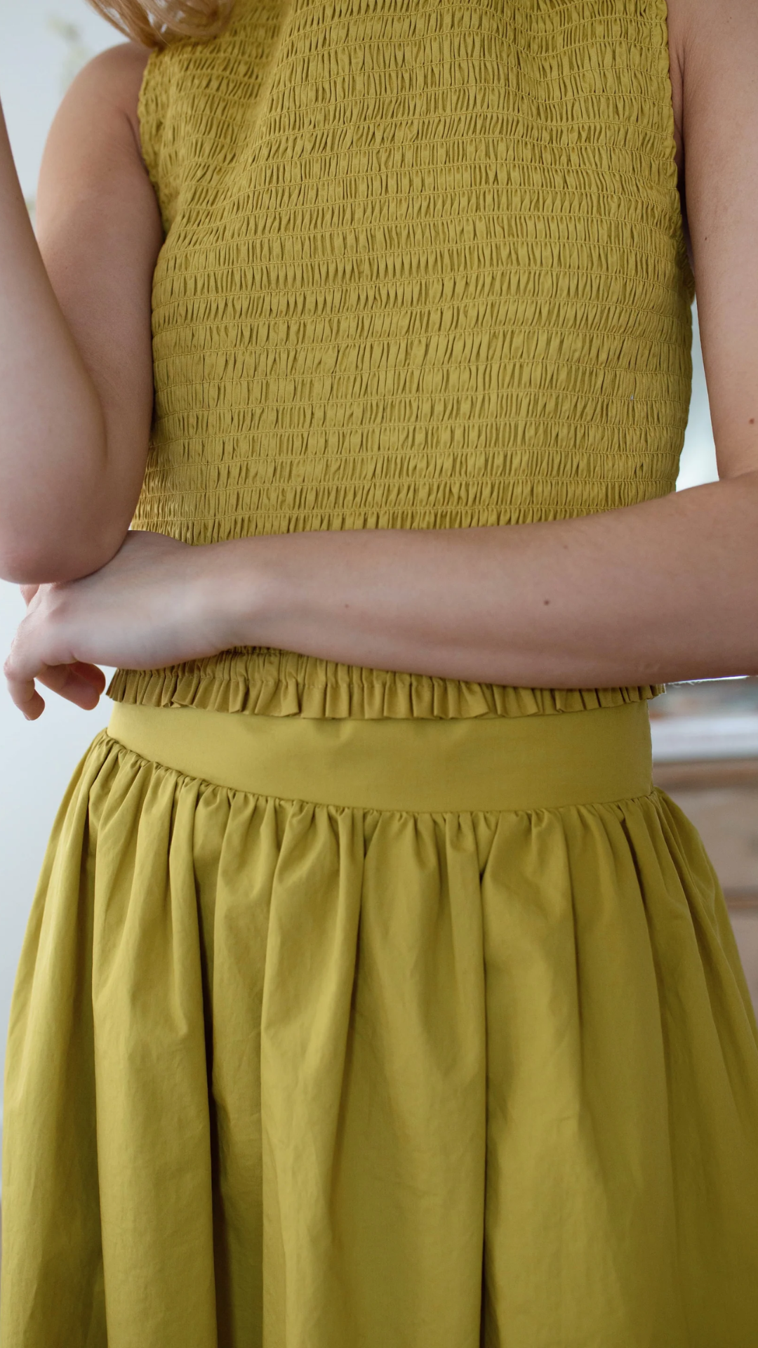 Studio model wearing the Charlotte Smocked Top, showcasing its flattering silhouette and high-waist length.