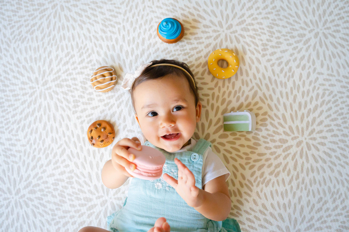 A delightful collection of Natural Rubber Teethers, Rattles, and Pretend Play toys in the shapes of a chocolate chip cookie, macaron, and donuts. These adorable, eco-friendly toys are perfect for babies to chew on and explore. Made from natural rubber, they are gentle on little teeth while offering a fun and playful design that encourages pretend play. Each piece is safe, non-toxic, and designed to engage babies with their realistic, charming shapes, making them an ideal addition to any baby's toy collectio