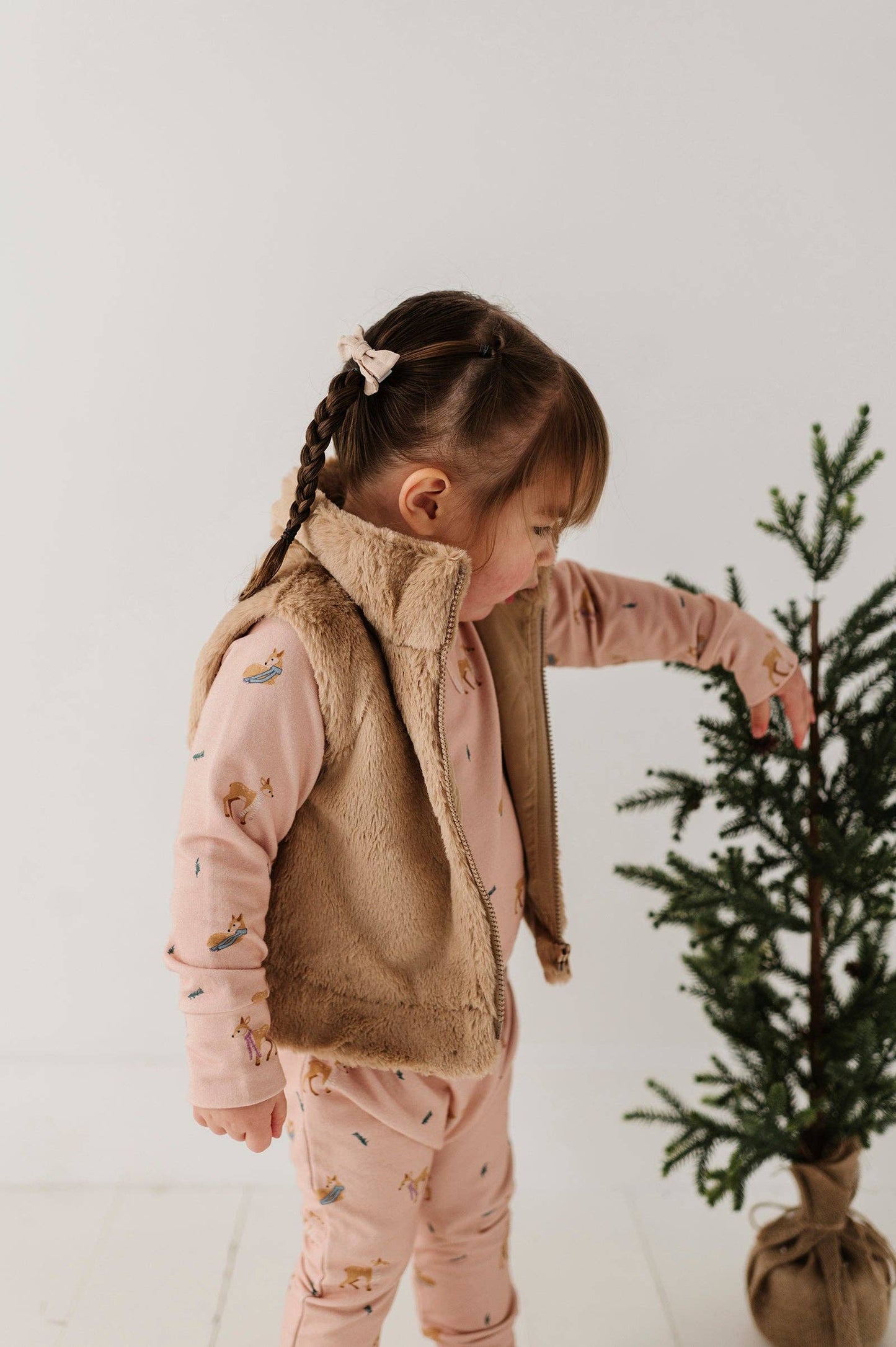 Young child twirling in faux fur vest, demonstrating playful movement and ultra-soft comfort for fall.