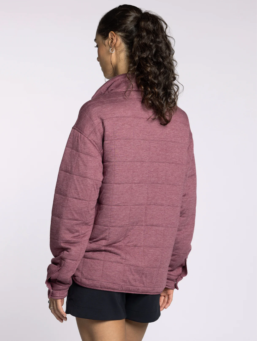 Side profile of model in the Indiana Pullover in rose, highlighting relaxed fit and hip-length cut.