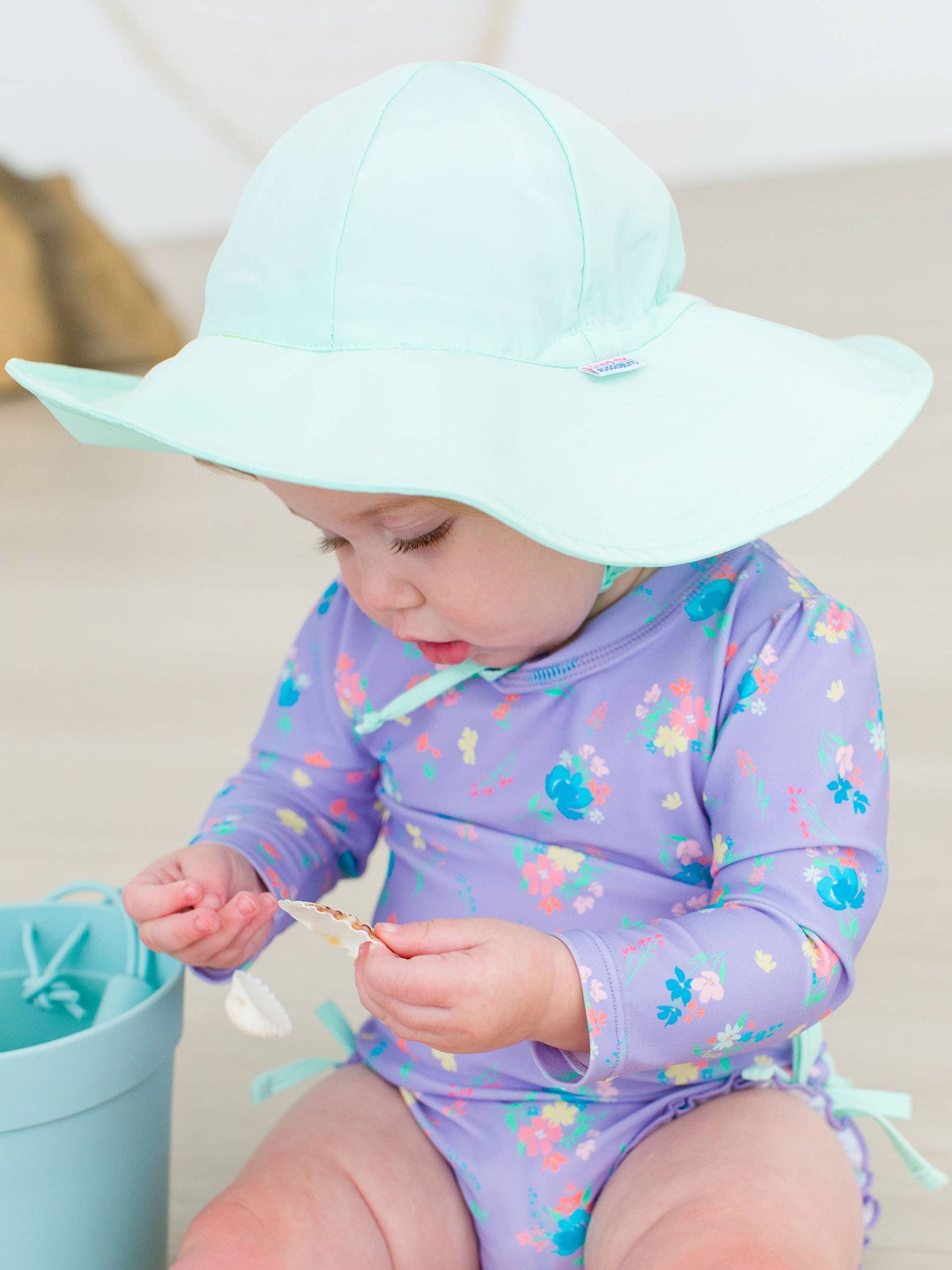 Baby smiling in mint sun hat with visible face, showing lightweight UPF 50+ design and happy summer vibes