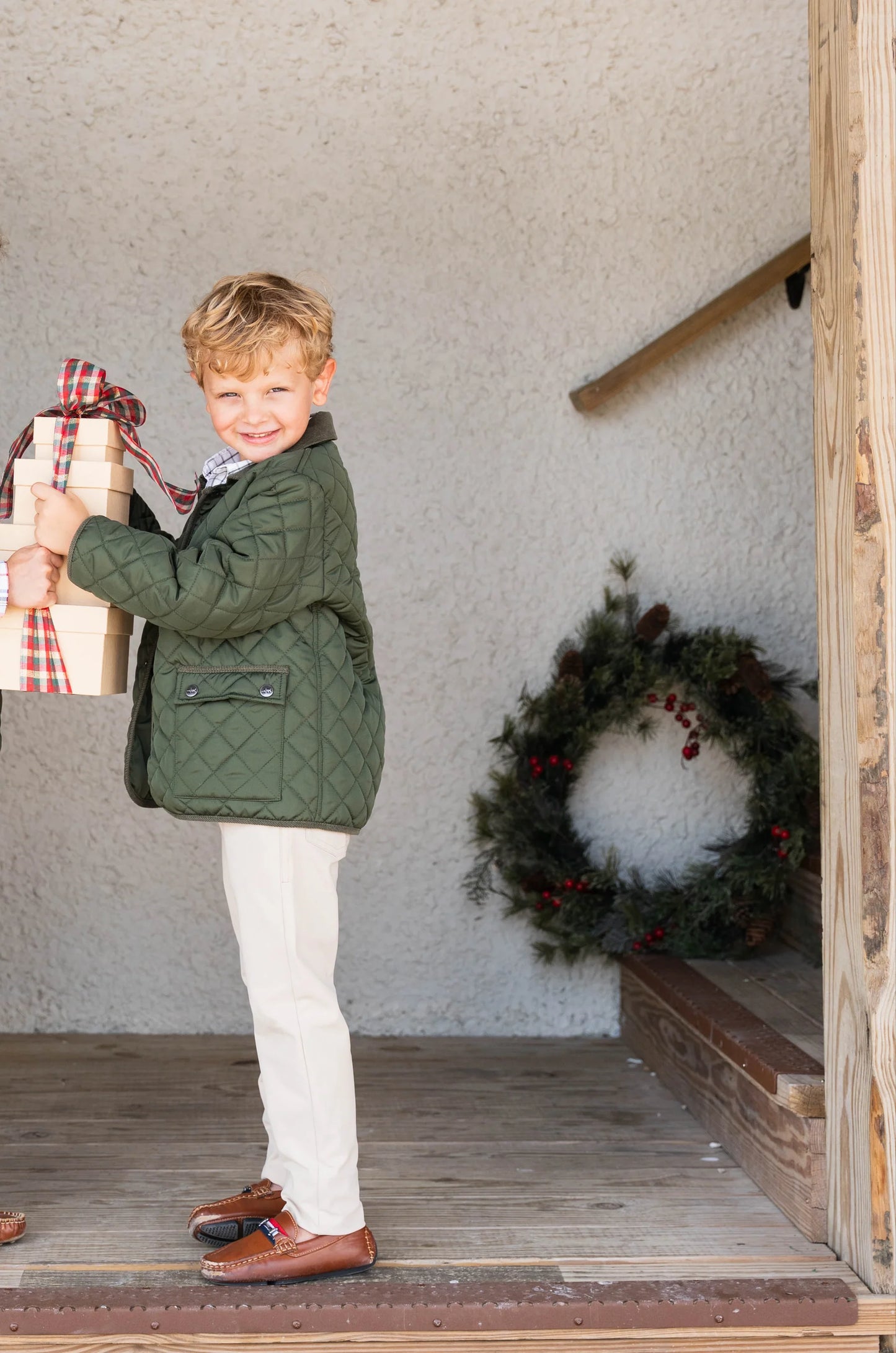 Smiling boy modeling Par Performance Pants paired with barn jacket, showcasing stylish, durable, and adjustable pants for active kids.