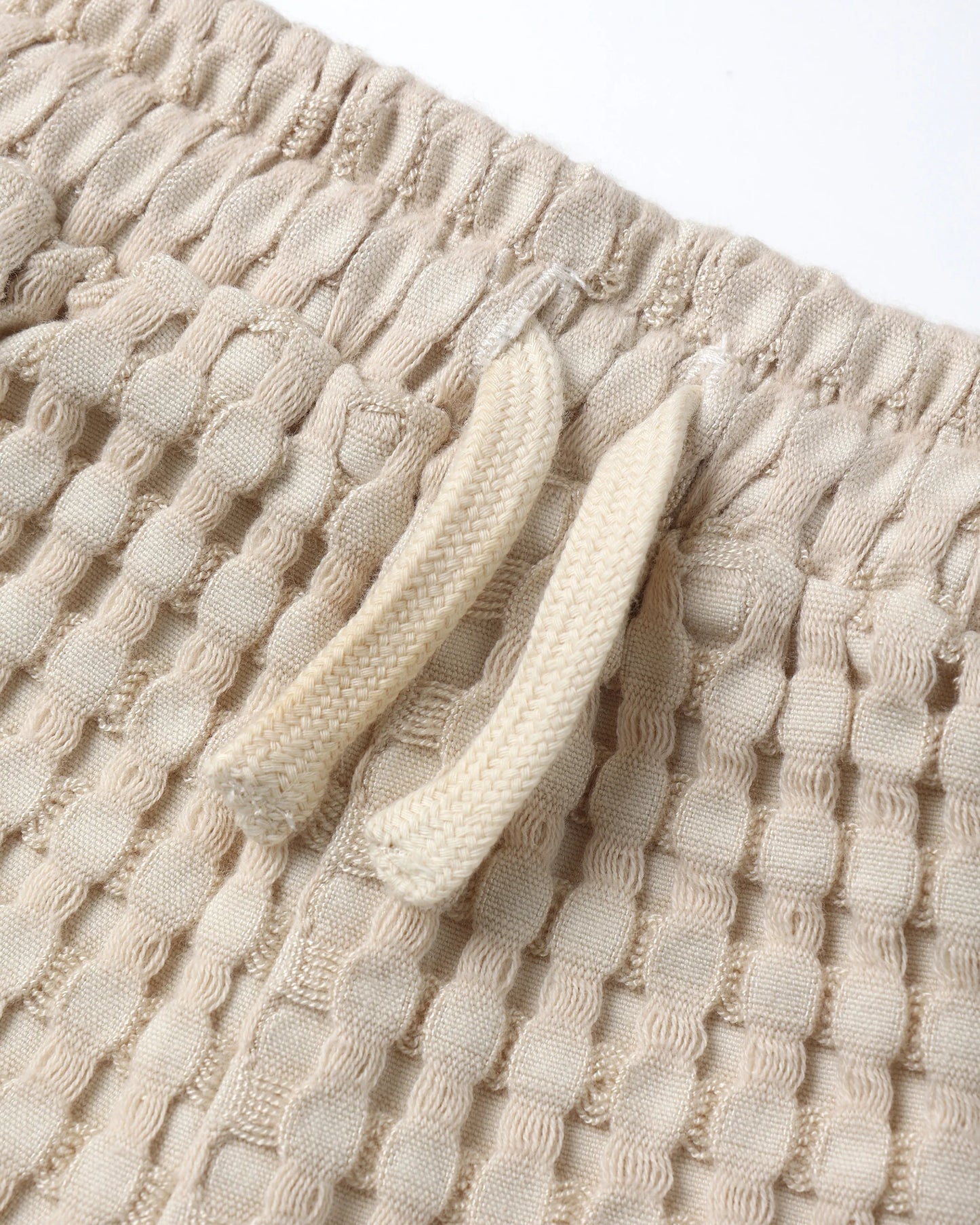 Close-up of Quincy Mae Flynn Set shorts, featuring chunky waffle texture and adjustable tie waist for a comfortable baby fit.