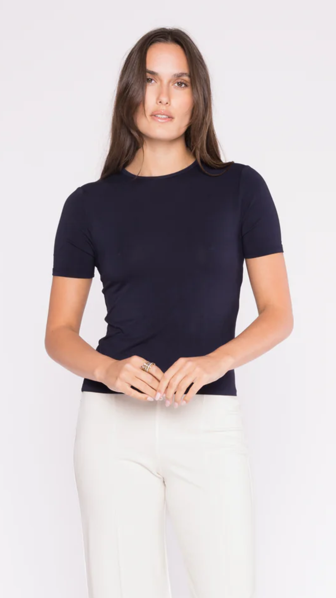 Model wearing the Ripley Rader Navy Fitted T-Shirt in a studio setting, showcasing its flattering fit, crew neckline, and versatile navy hue perfect for layering or wearing alone.