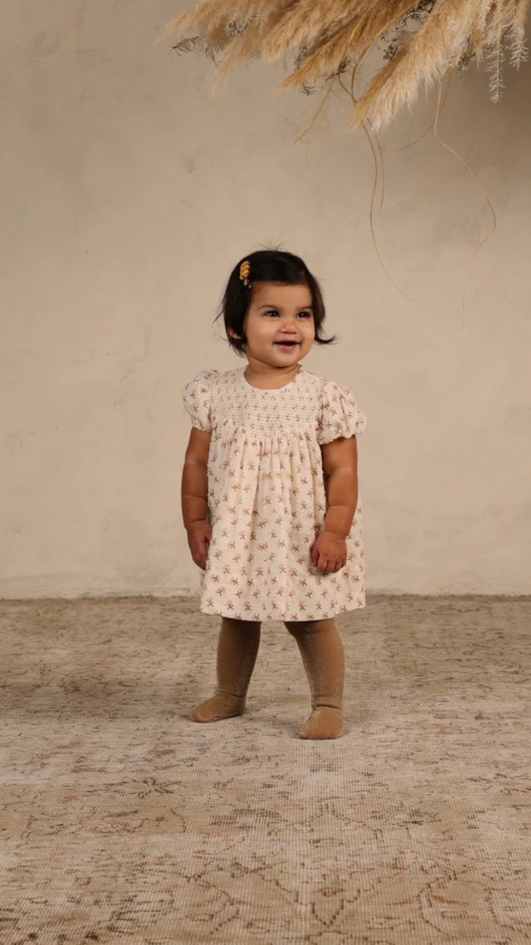 Toddler modeling Noralee Shimmer Tights in Golden, paired with a coordinating dress for a festive fall look.