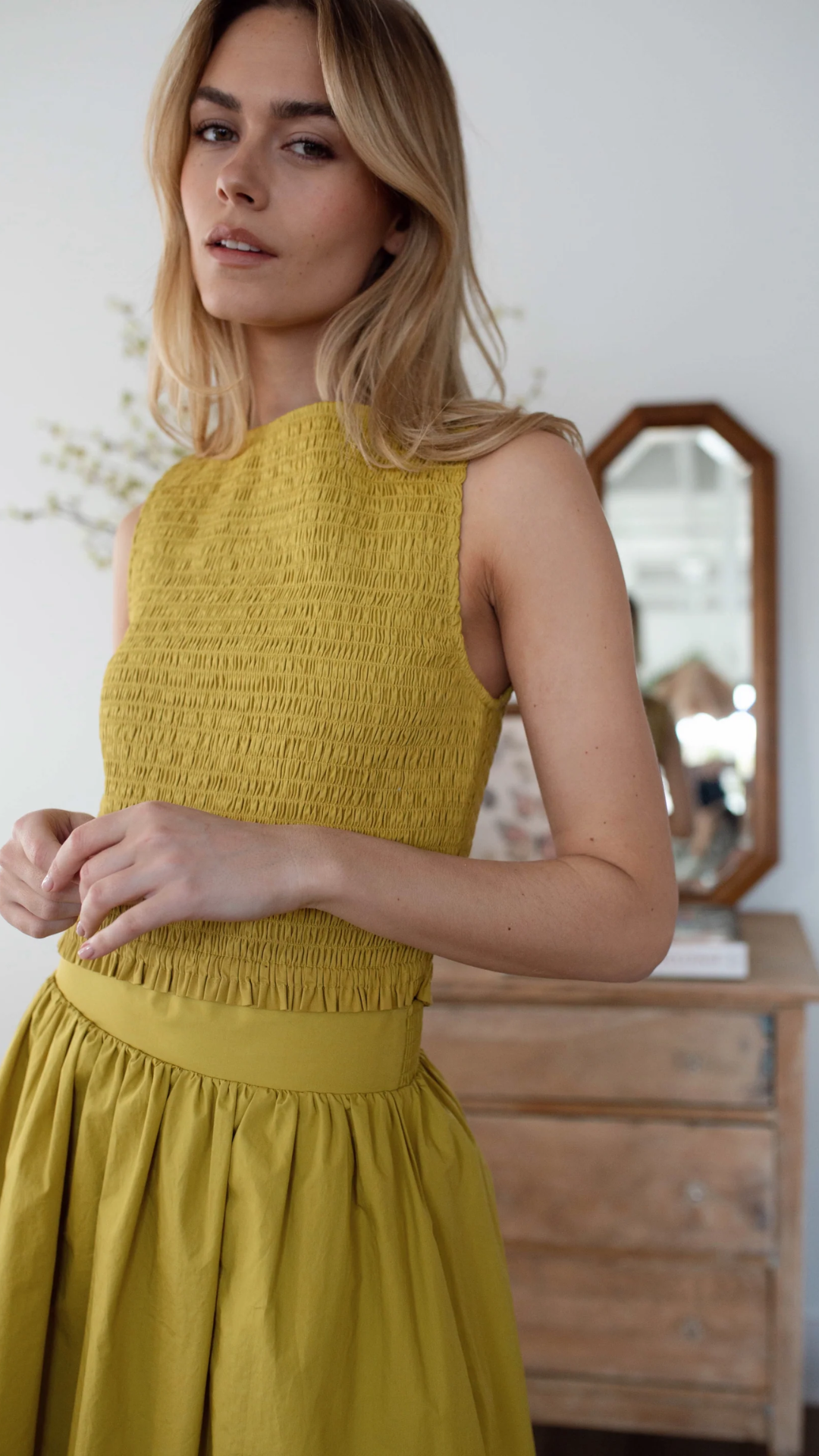 Studio model wearing the Charlotte Smocked Top, showcasing its flattering silhouette and high-waist length.