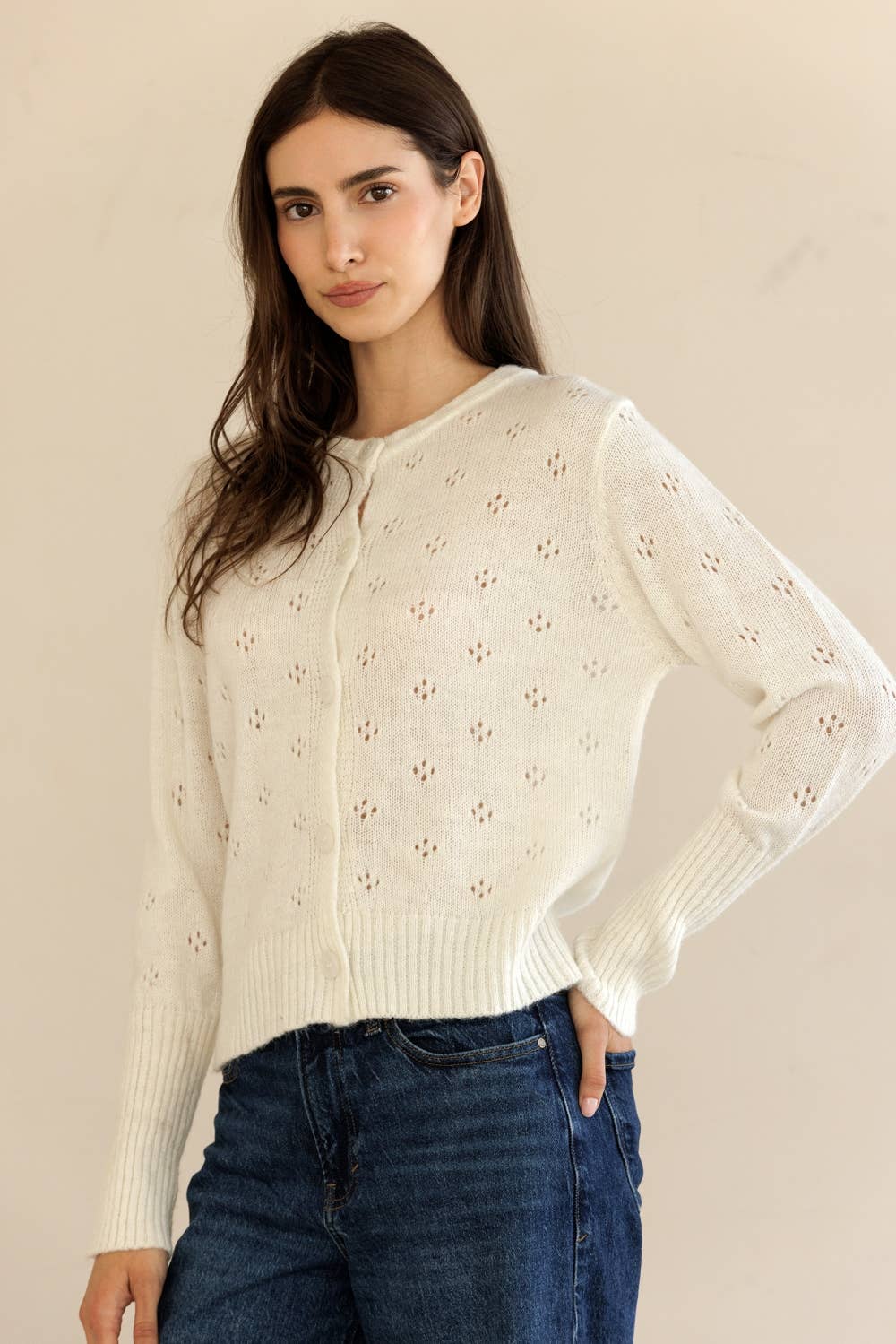 Side view of model in Storia Ribbed Knit Cropped Cardigan, hand on hip, showing ribbed texture and fit