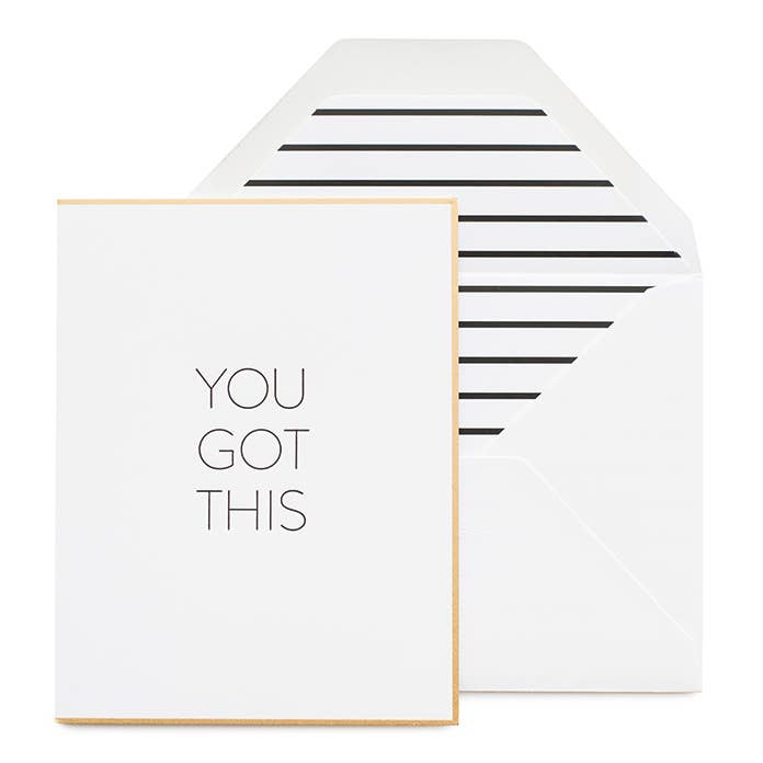 Flat lay of You Got This letterpress card with black ink on white paper, paired with white envelope and black stripe liner