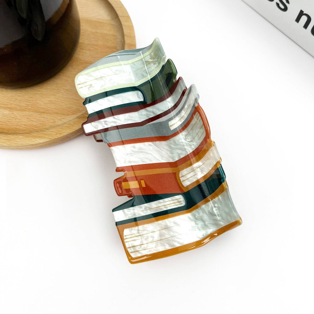 Close-up of book-themed acrylic hair clip for readers