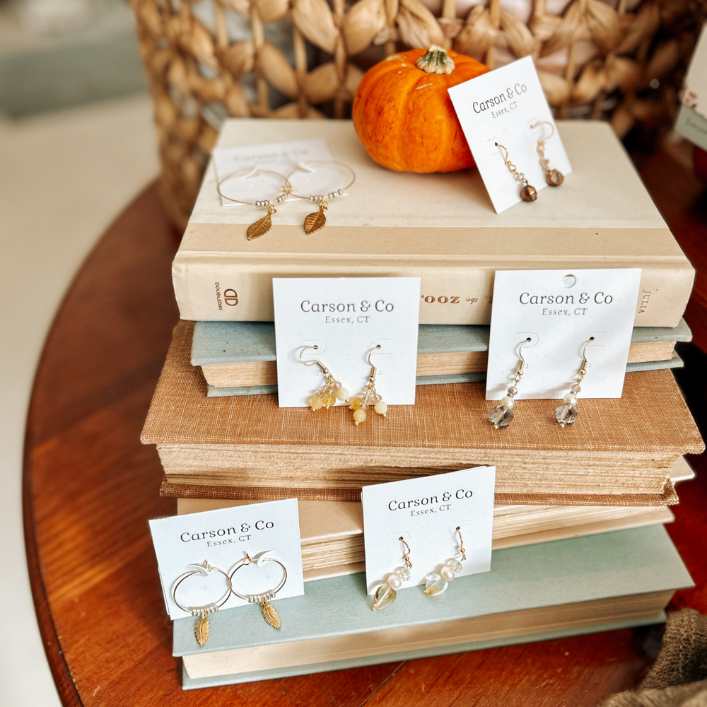 Carson & Co jewelry displayed on books in-store at Grace & Haven, handmade by local artisan Gill in Essex, reflecting a commitment to community support.