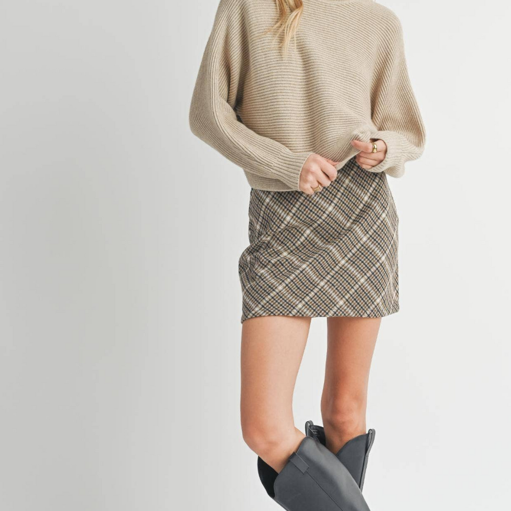 
                      
                        Full-body view of the model wearing the Anya Turtleneck Sweater with a mini skirt and boots, perfect for transitioning from day to night.
                      
                    