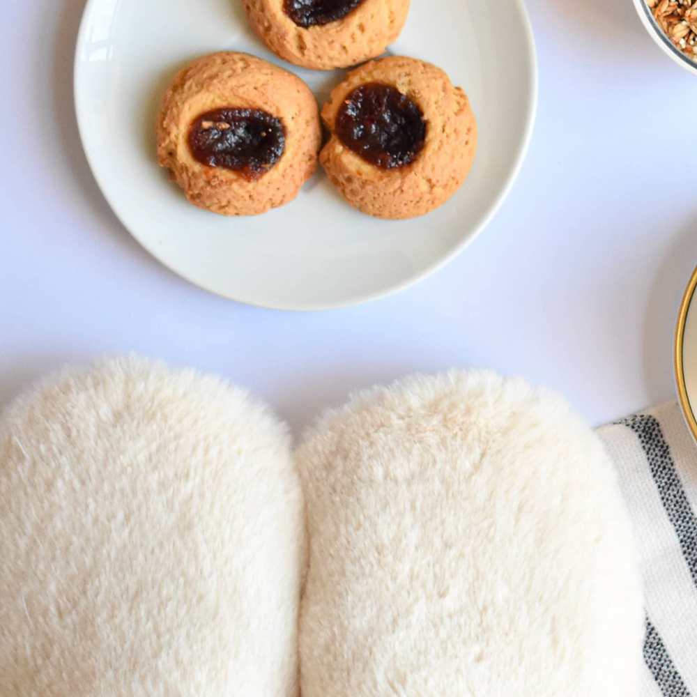 Pantuss Aromatherapy Slippers beside indulgent treats, highlighting a self-care routine with soothing lavender and flax-filled microwaveable insoles.