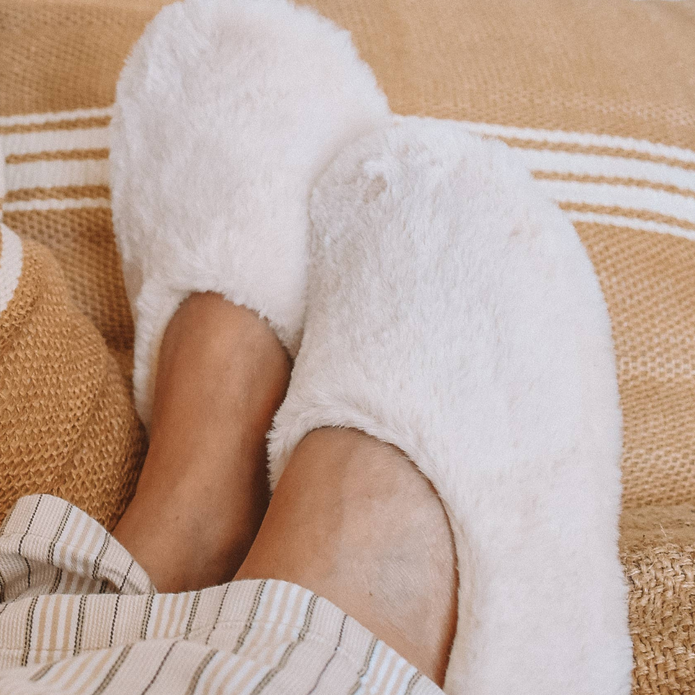 Feet crossed in Pantuss Aromatherapy Slippers, filled with lavender flowers and flax seeds, offering calming warmth and comfort for relaxation.