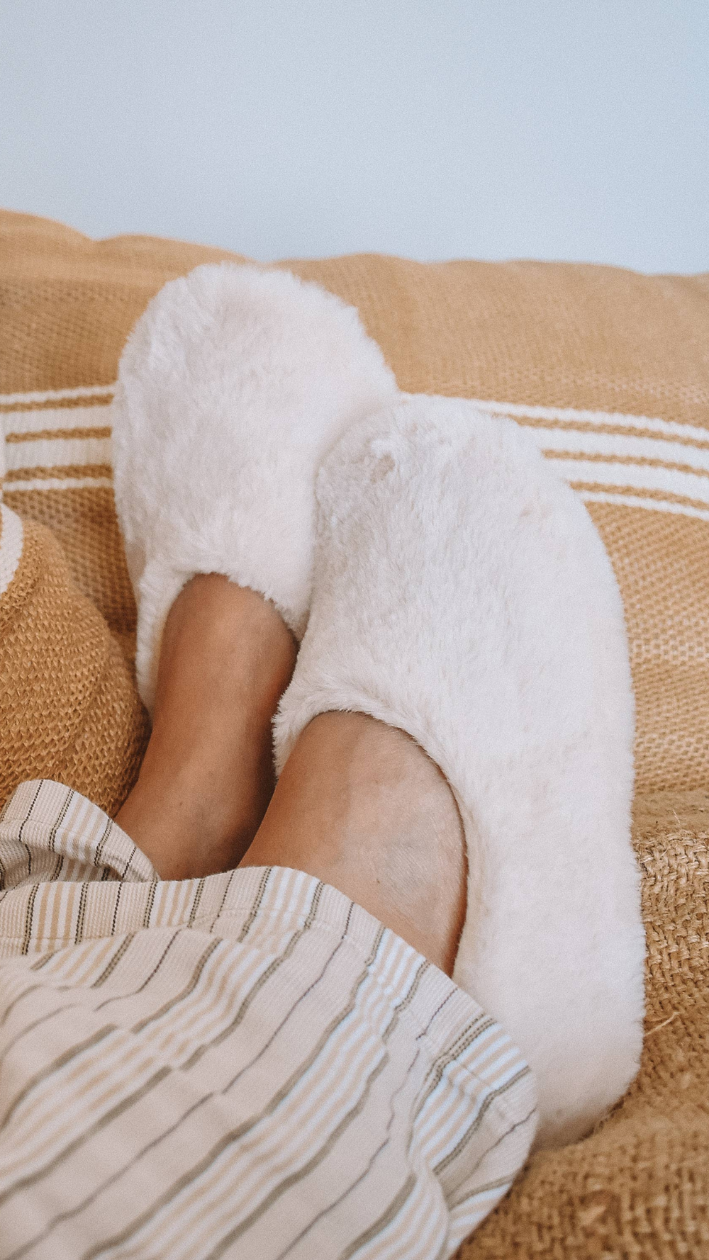 Feet crossed in Pantuss Aromatherapy Slippers, filled with lavender flowers and flax seeds, offering calming warmth and comfort for relaxation.