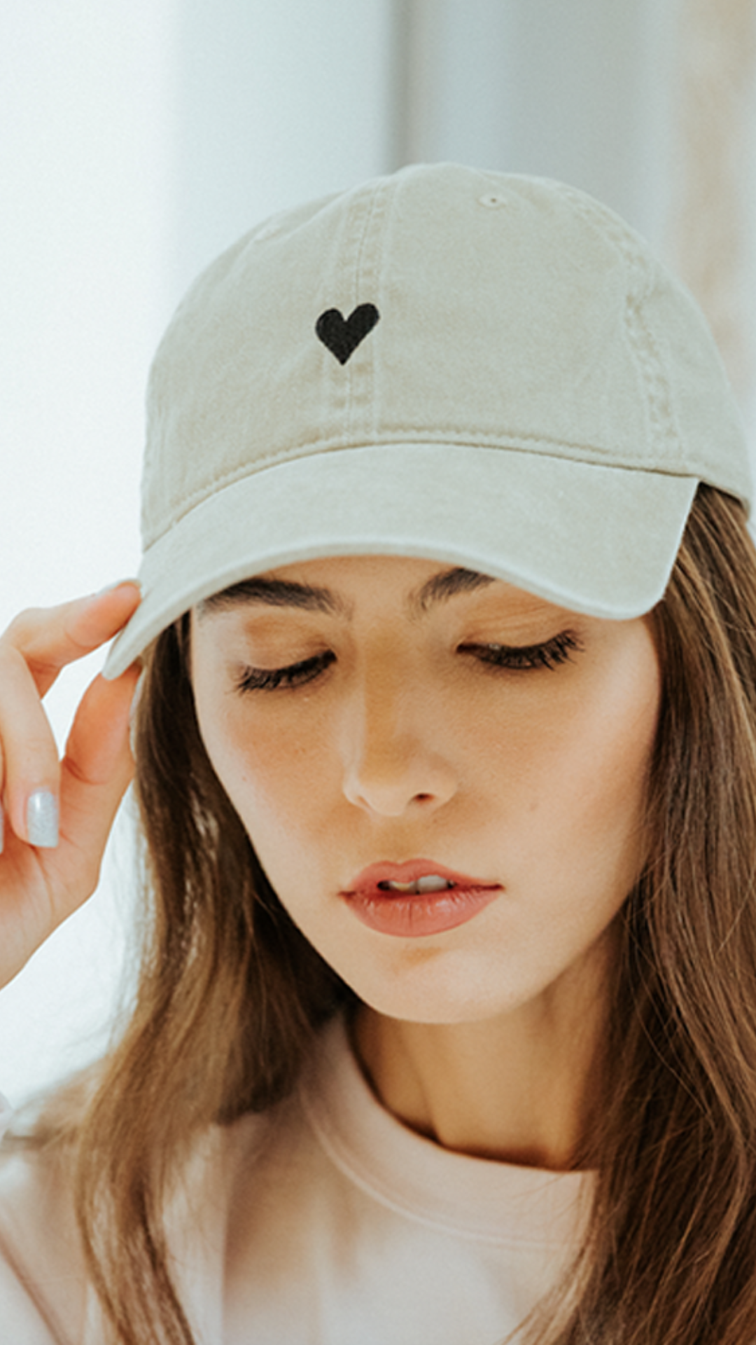 Close-up of the adjustable strap on the Beige Heart Hat in light beige.