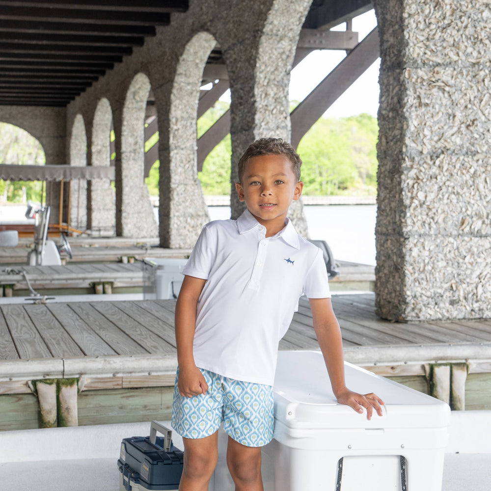 
                      
                        A young boy wearing the Saltwater Boys white polo, ready for a fun day of fishing. The comfortable, classic polo is perfect for outdoor adventures and is a must-have for summer activities.
                      
                    