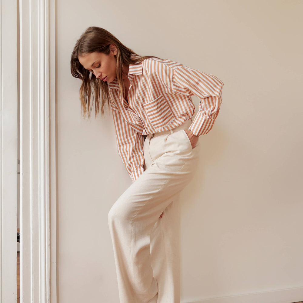 
                      
                        Oversized Celia Striped Shirt in camel with modern mixed stripes, perfect button-down for versatile casual or date night wear
                      
                    