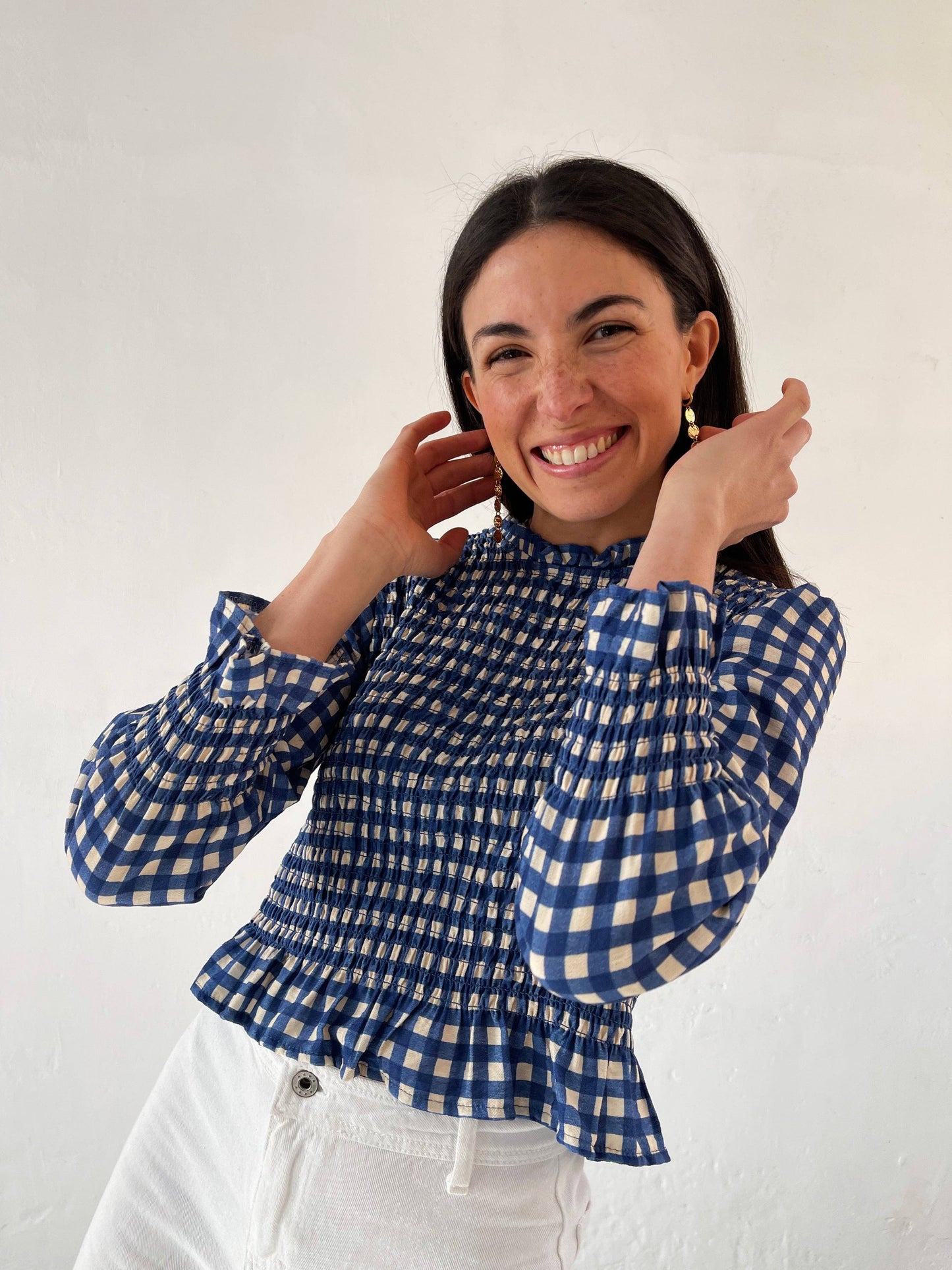 Elegant blue blouse with ruffle accents at the neckline, cuffs, and hem, perfect for women.