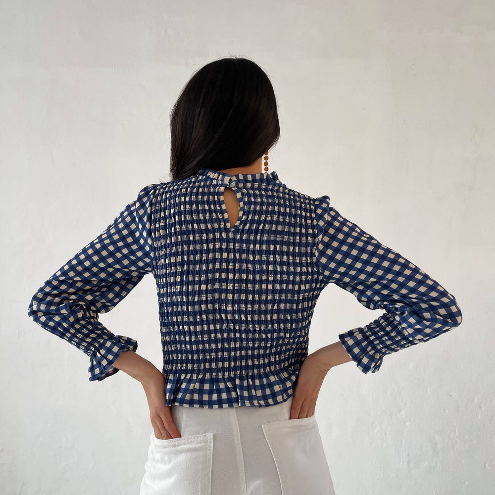 
                      
                         Crafted with intricate honeycomb detailing, this blouse features delicate ruffles at the bottom hem, neckline, and cuffs, adding a feminine charm to its design. 
                      
                    