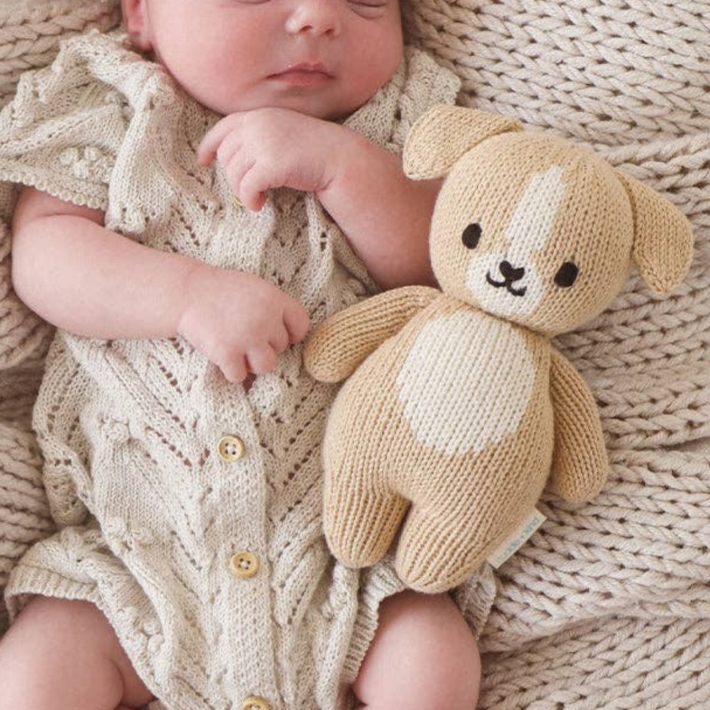 Happy child cuddling the Baby Puppy doll, showing off its perfect size for little hands and its cuddly, soft texture.