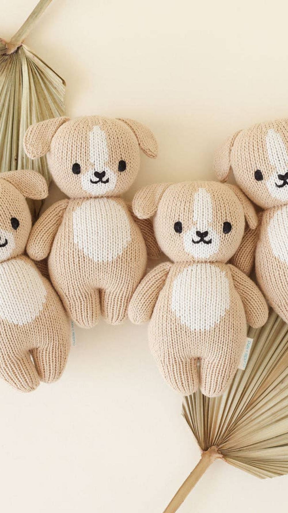 Four Cuddle + Kind Baby Puppies laid together in a charming arrangement, showing off their unique handmade qualities and perfect size for cuddling.