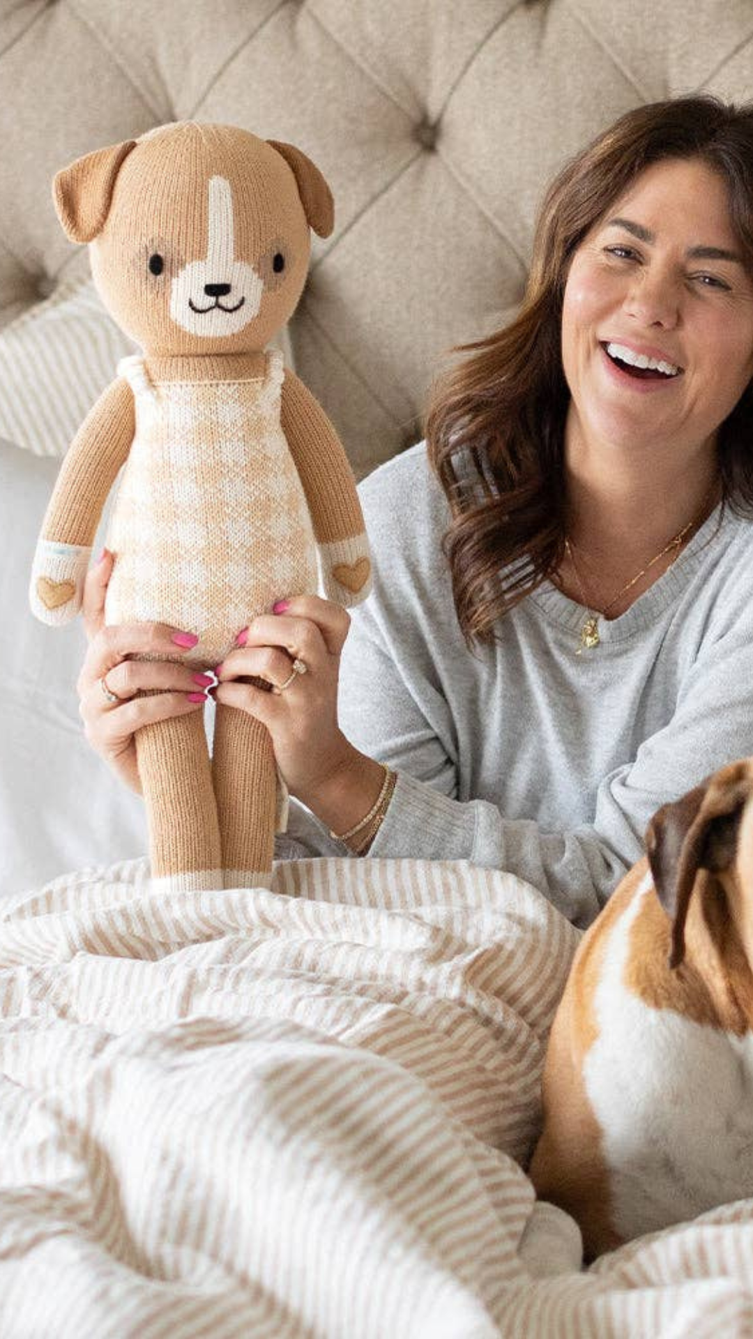 Jillian Harris lovingly holding the Hayden the Dog doll from her limited edition collection with Cuddle + Kind, showcasing the special design and craftsmanship.