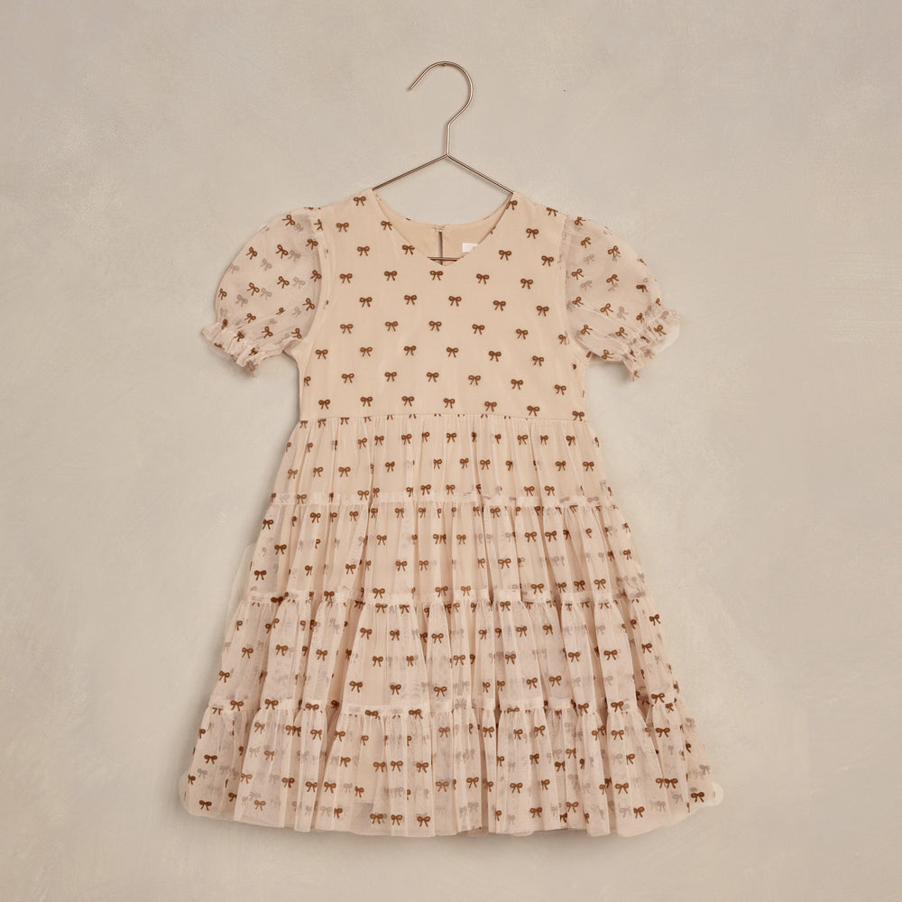 The Dottie Dress by Noralee featuring a cute bow pattern and trendy puff sleeves, perfect for children’s fashion.