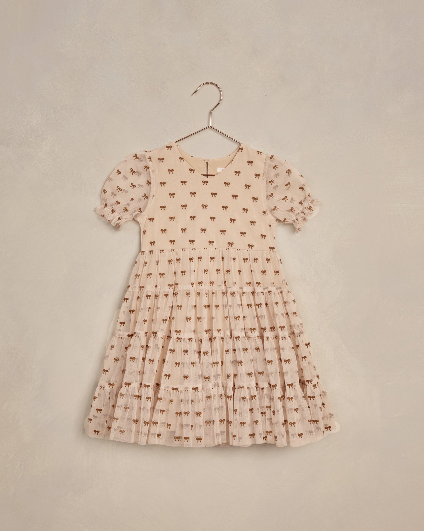 The Dottie Dress by Noralee featuring a cute bow pattern and trendy puff sleeves, perfect for children’s fashion.