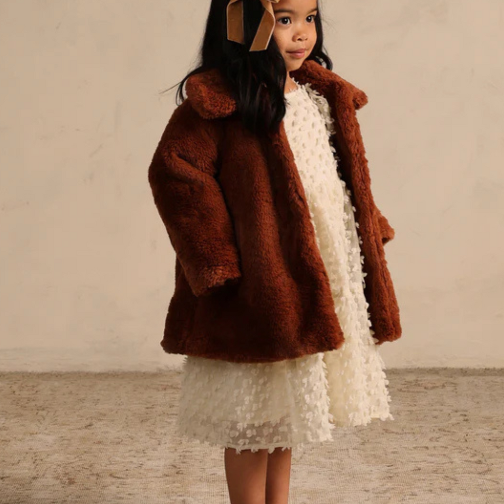 
                      
                        Side view of Eloise Coat in Copper on model, showcasing slightly oversized fit and warm faux fur fabric for cozy style.
                      
                    