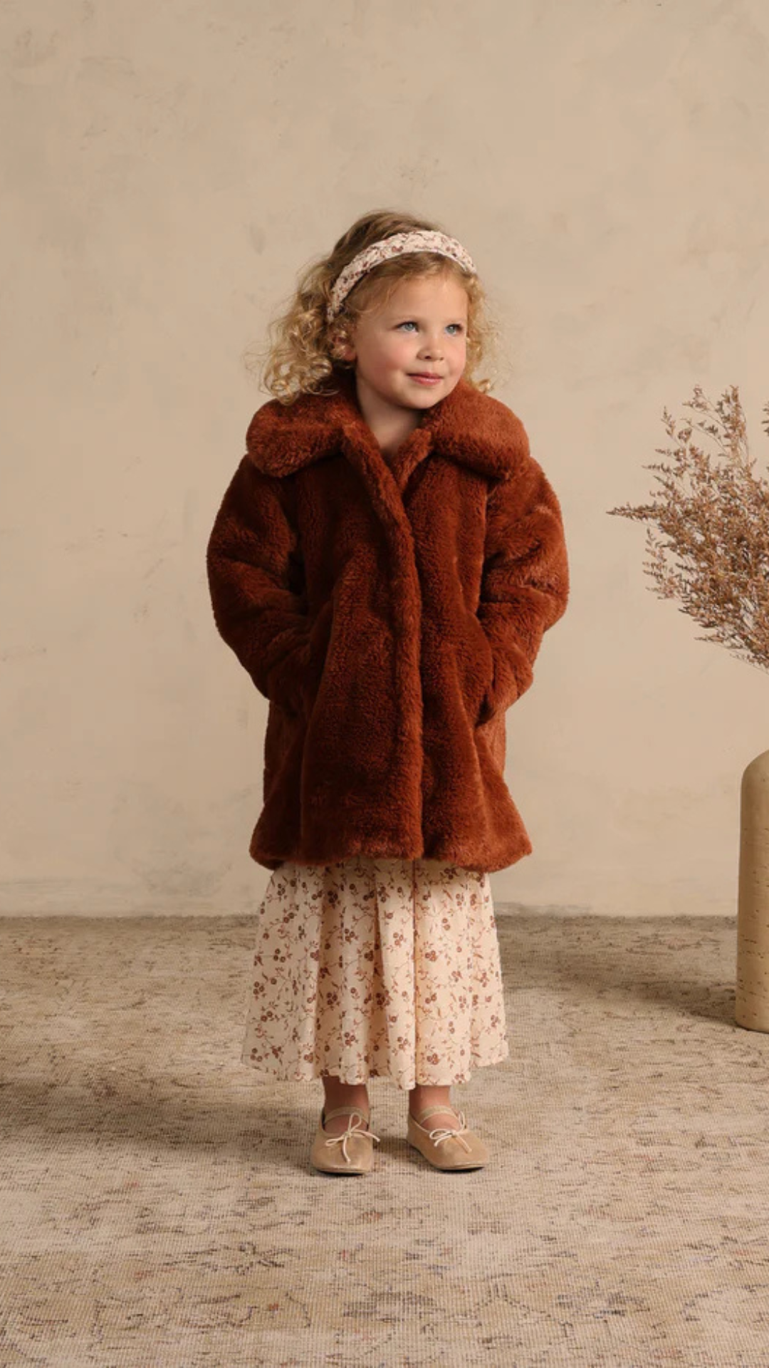 Full view of Eloise Coat in Copper on model, a trendy faux fur coat for kids with practical front pockets and hidden snaps.