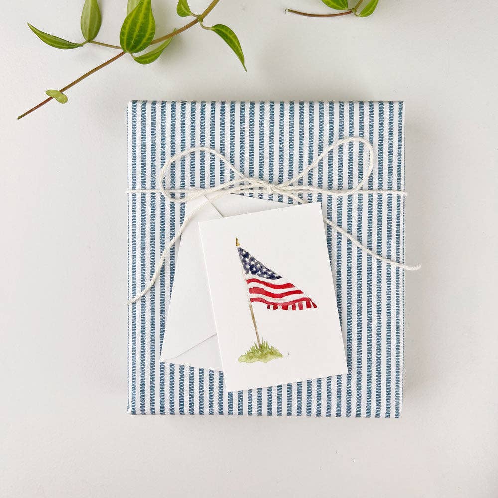 Emily Lex watercolor mini note card featuring a delicate design, paired with a matching envelope, resting atop a beautifully wrapped gift. Perfect for adding a personal touch to any present, this charming note card is ideal for special occasions. Available at Grace & Haven for those seeking a thoughtful and elegant gift-giving experience.
