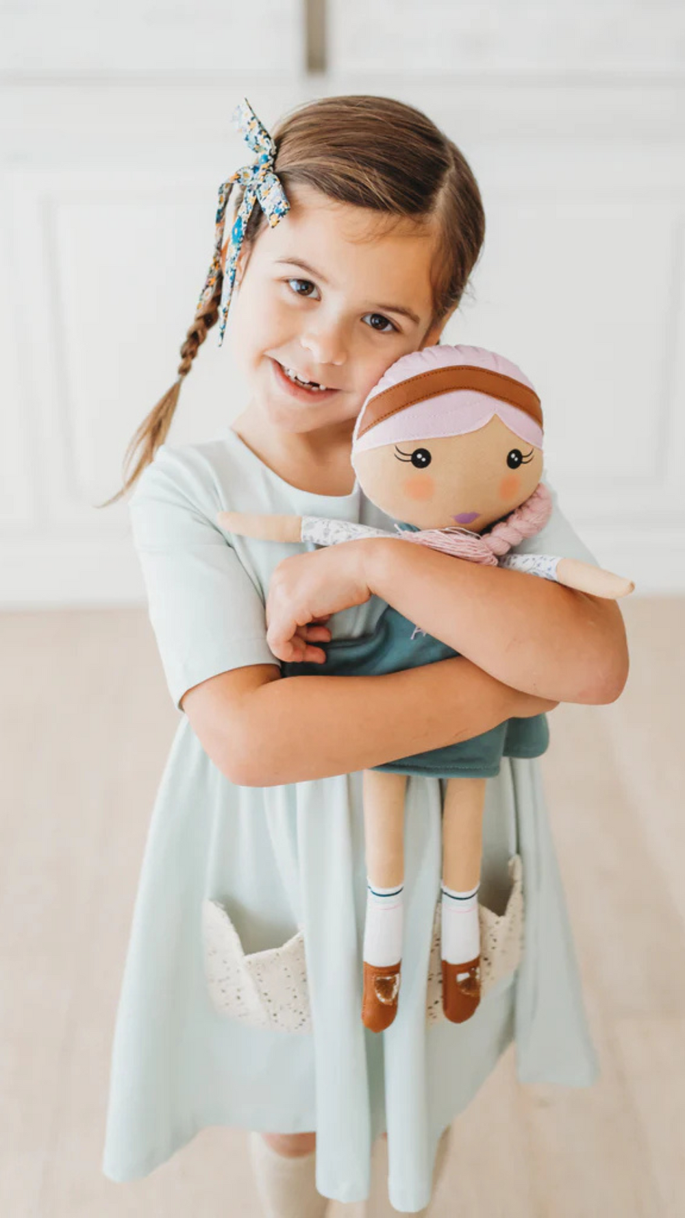 Little girl hugging her Fair Kindness Doll, showcasing the doll’s comforting design and positive message of kindness.