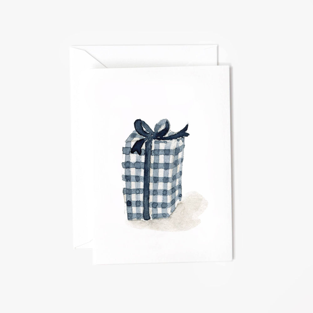 Flat lay of the Emily Lex Mini Notecard and envelope featuring her watercolor illustration of a gift wrapped in navy gingham paper with a ribbon. The delicate design captures the charm of thoughtful gifting, making it perfect for special occasions. The notecard is placed next to the matching envelope, showcasing Emily Lex’s signature watercolor style, offering a personalized touch to any note. Ideal for birthdays, thank-yous, or any celebration, this card set embodies warmth and heartfelt sentiment.