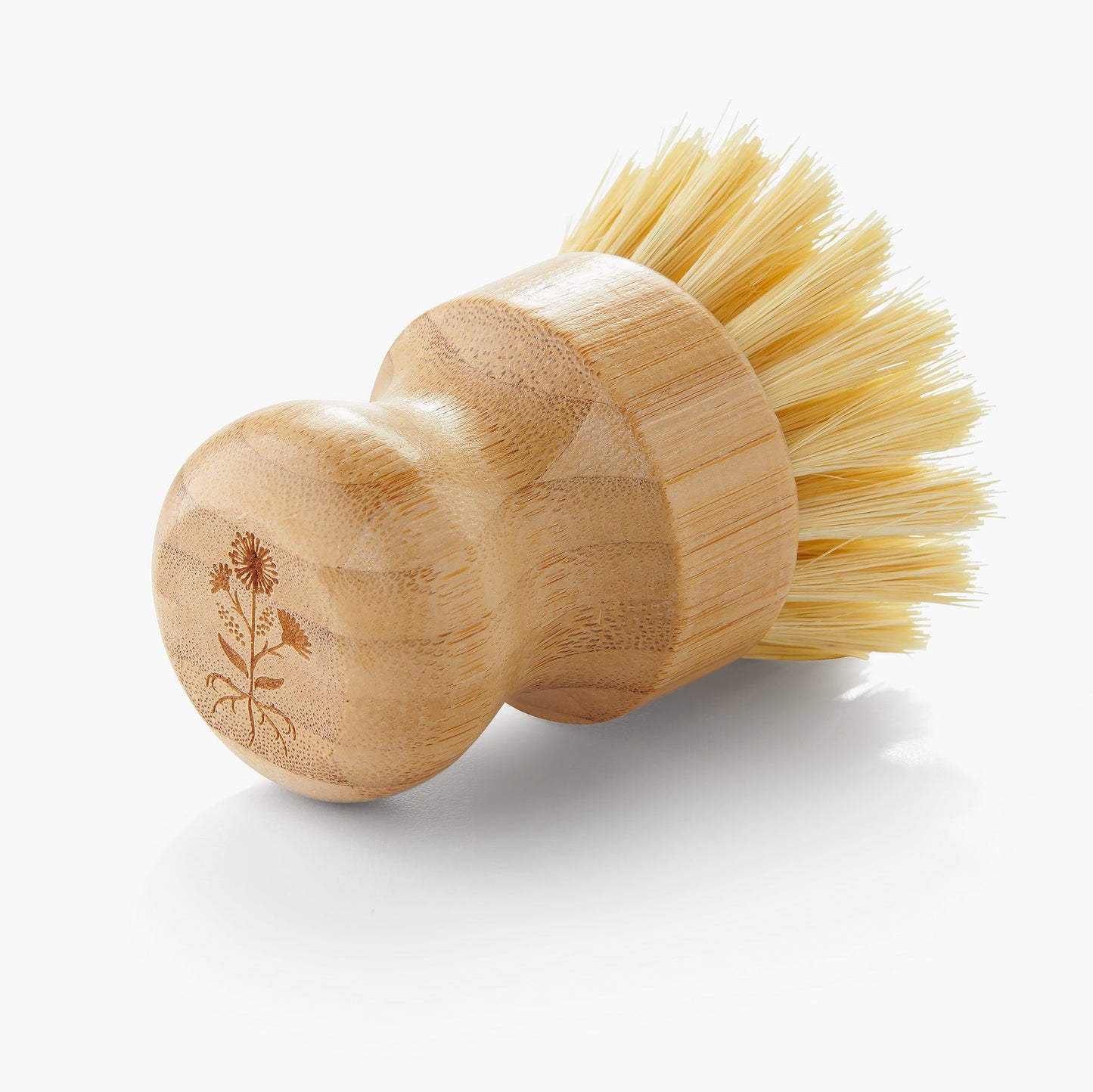 Floraco wooden dish brush laying on countertop, a sustainable alternative to plastic scrubbers
