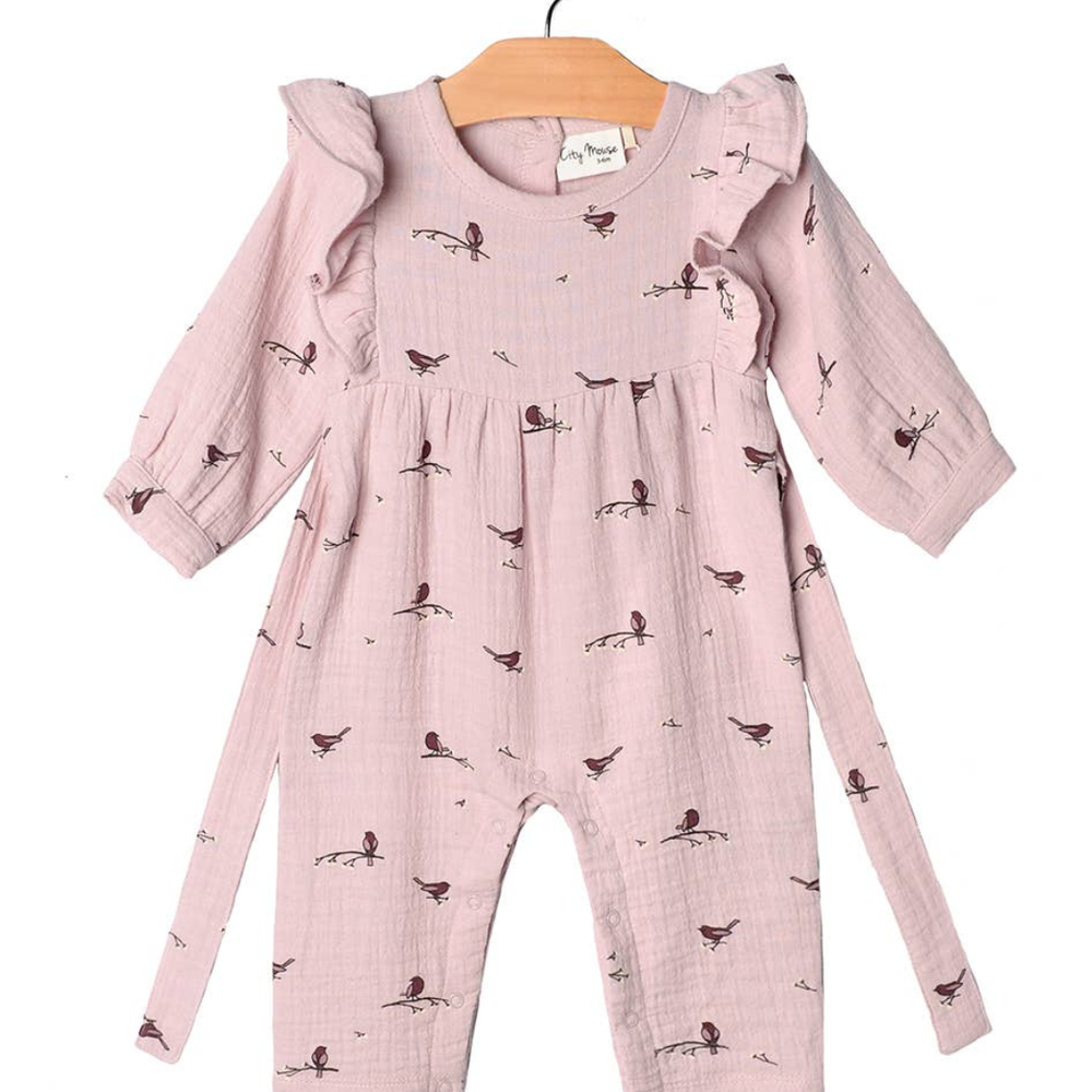 Flat lay of the Flutter Sleeve Long Romper in Fall Lavender Birds print by City Mouse, featuring soft muslin fabric, flutter sleeves, and a back tie detail, styled with delicate lavender floral accents.