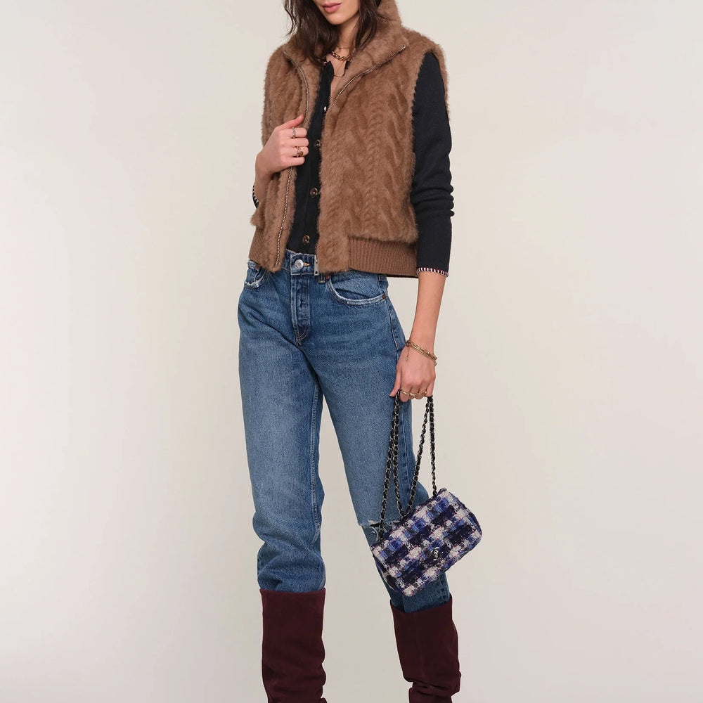 
                      
                        Full-length view of The Liana Vest on model paired with denim and tall boots, showcasing complete outfit and cozy outerwear style.
                      
                    