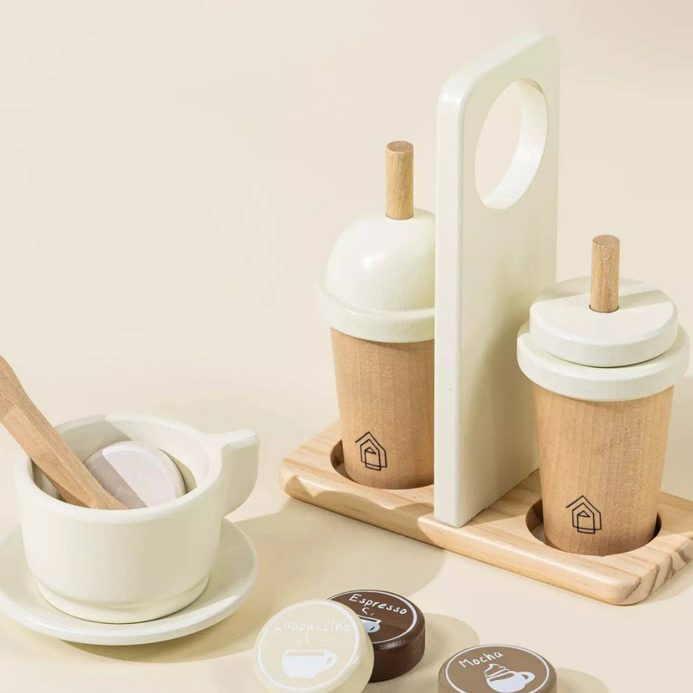 
                      
                        Close-up of the complete Wooden Coffee Maker Set accessories: a coffee cup, saucer, wooden coffee tokens, spoon, and to-go cups with a carrier, all designed to enhance imaginative play for children.
                      
                    