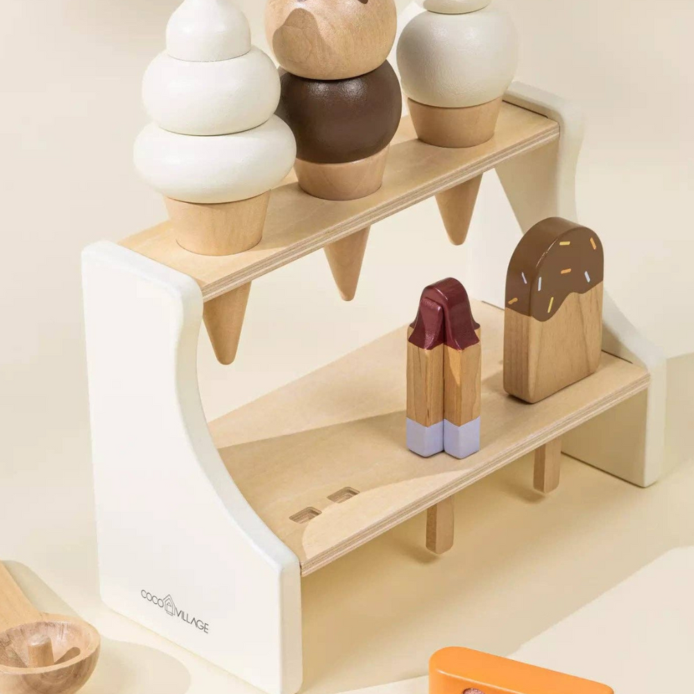 Side view of Wooden Ice Cream Stand with a creamsicle ice pop and ice cream scoop laying beside it, perfect for pretend ice cream and dessert play while fostering imaginative play and fine motor skills.