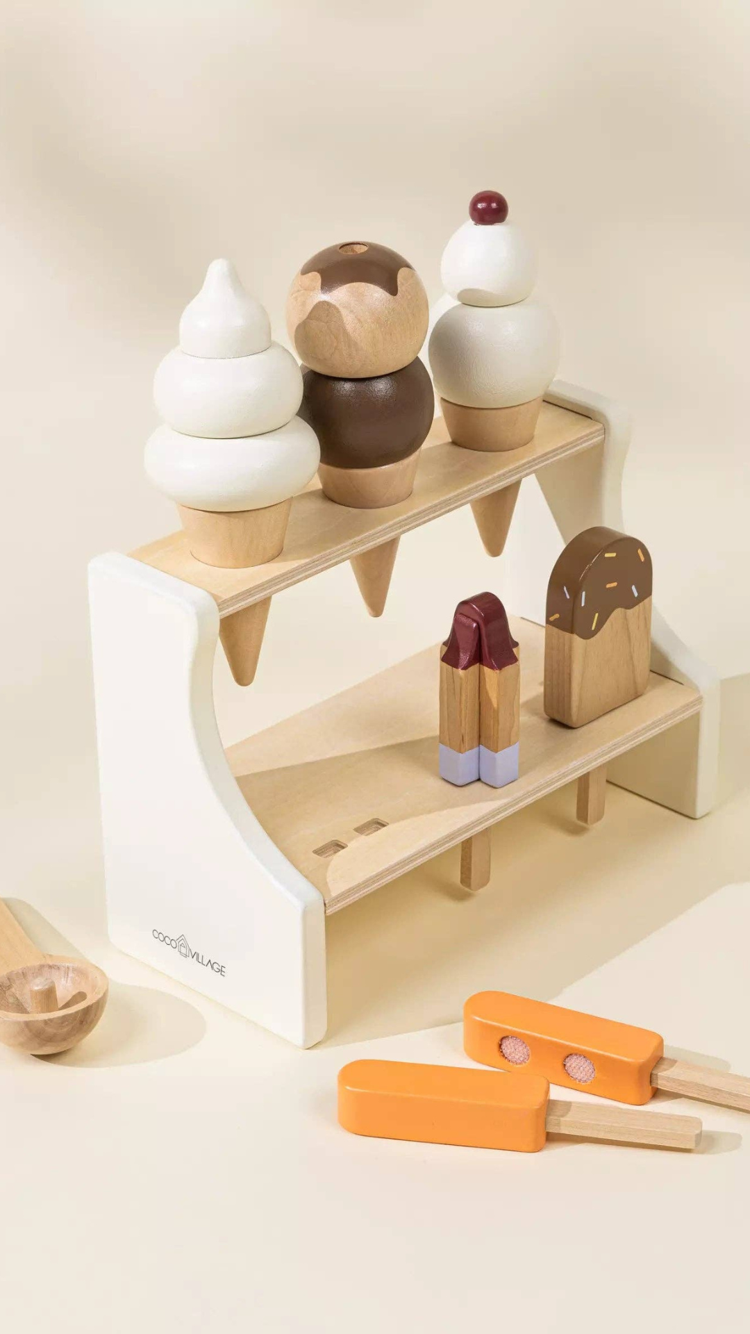 Side view of Wooden Ice Cream Stand with a creamsicle ice pop and ice cream scoop laying beside it, perfect for pretend ice cream and dessert play while fostering imaginative play and fine motor skills.