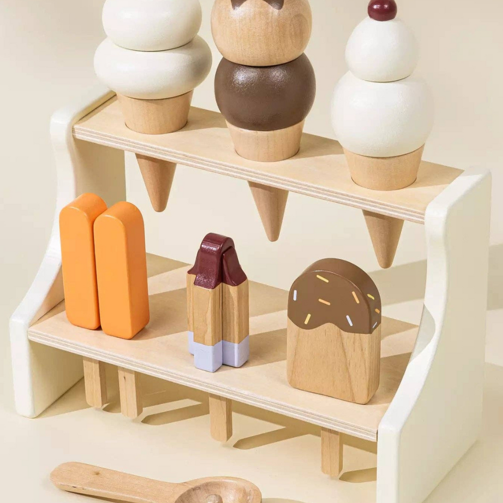 
                      
                        Angled view of the Wooden Ice Cream Stand playset, showing a complete set of ice cream cones, ice pops, and a spoon, designed to encourage children’s creativity and hand-eye coordination through pretend play.
                      
                    