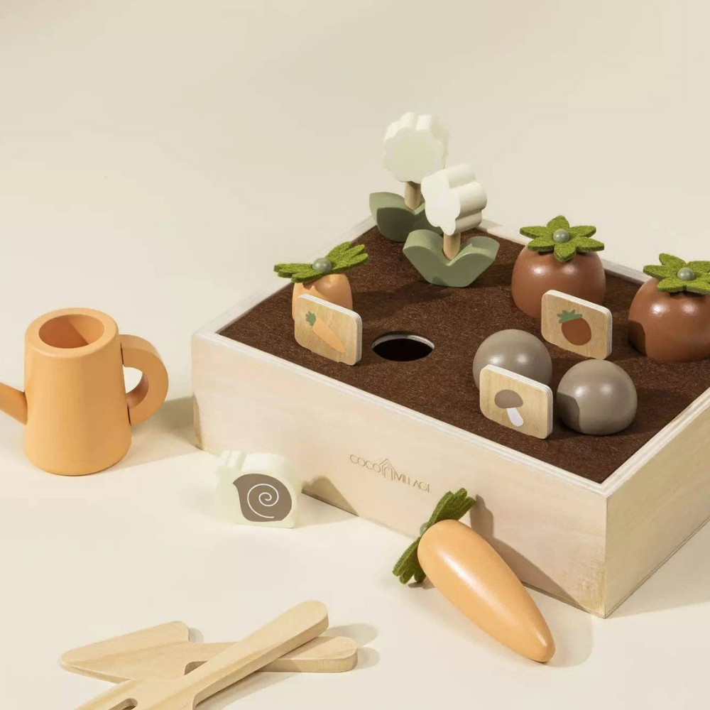 Wooden Gardening Playset displayed with vegetables like carrots and tomatoes ready to be "picked," alongside gardening tools and a watering can, encouraging imaginative nature play and skill development.