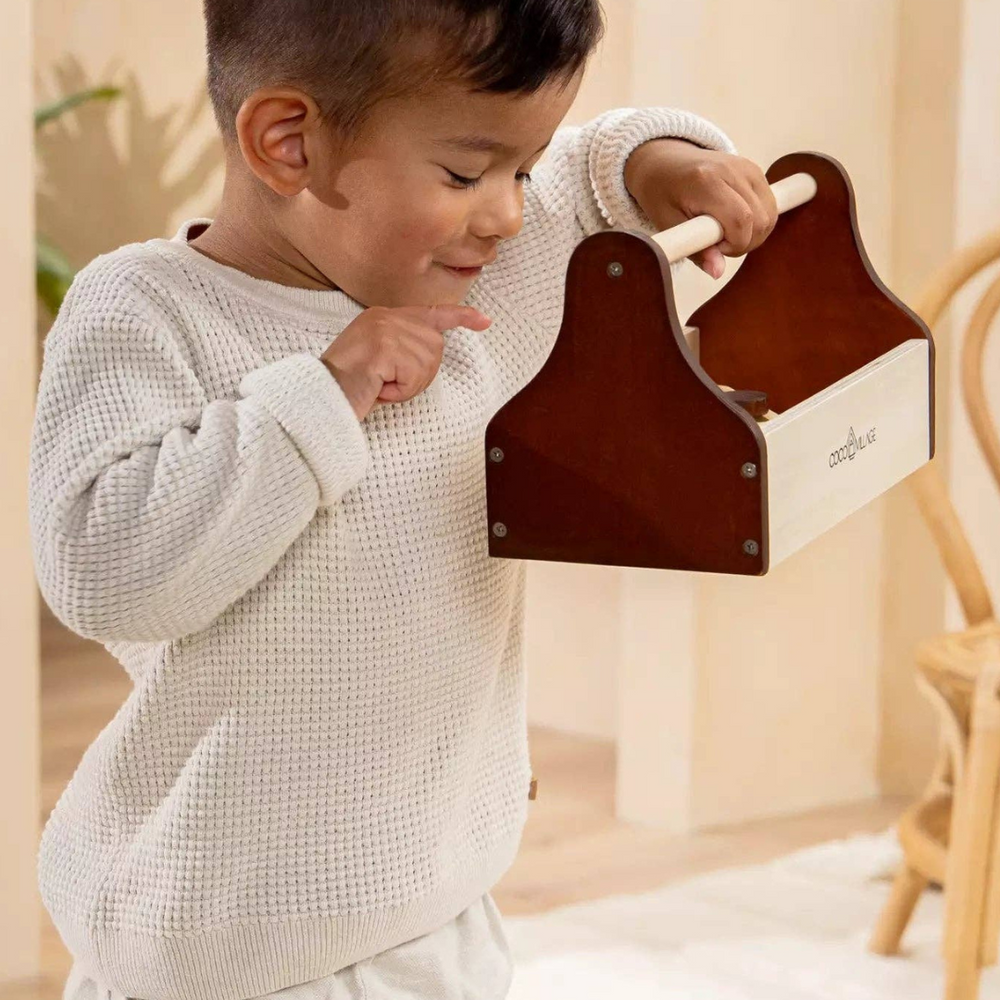 Child exploring the Wooden Tool Playset toolbox, designed to inspire creativity and imaginative play with high-quality pinewood tools for budding handymen and handywomen.