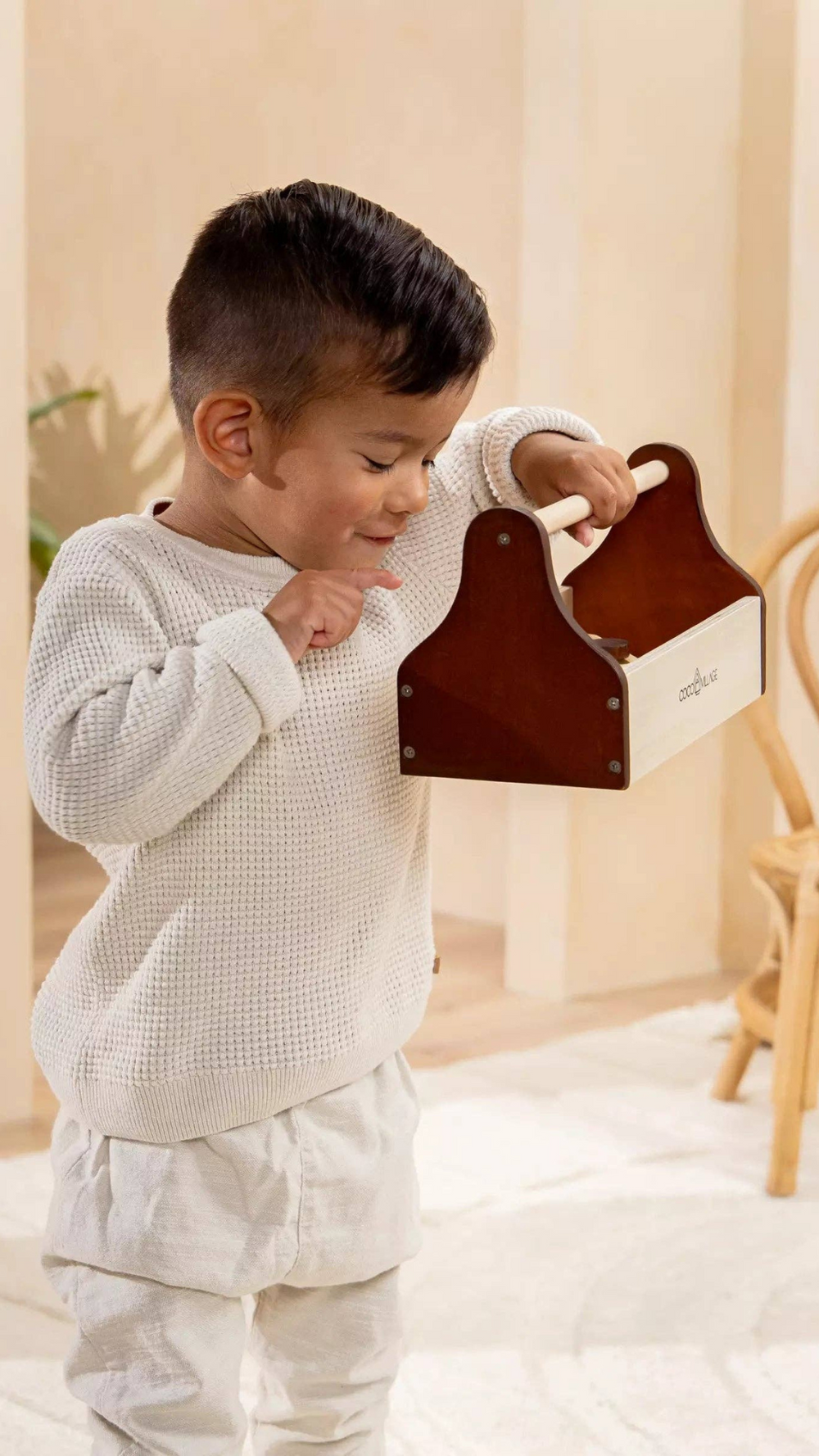 Child exploring the Wooden Tool Playset toolbox, designed to inspire creativity and imaginative play with high-quality pinewood tools for budding handymen and handywomen.