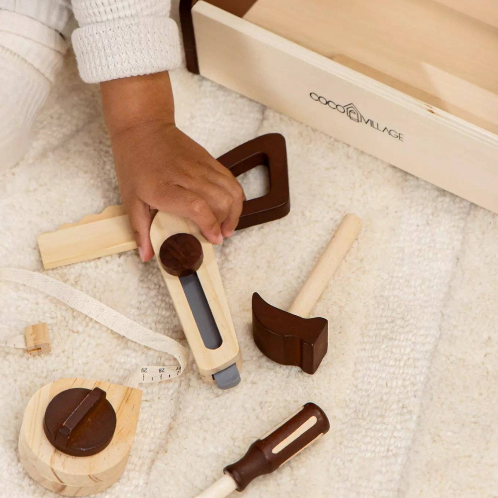 
                      
                        Child handling tools next to the Wooden Tool Playset toolbox, encouraging hands-on learning and creativity with safe, high-quality pinewood tools for children aged 3 and up.
                      
                    