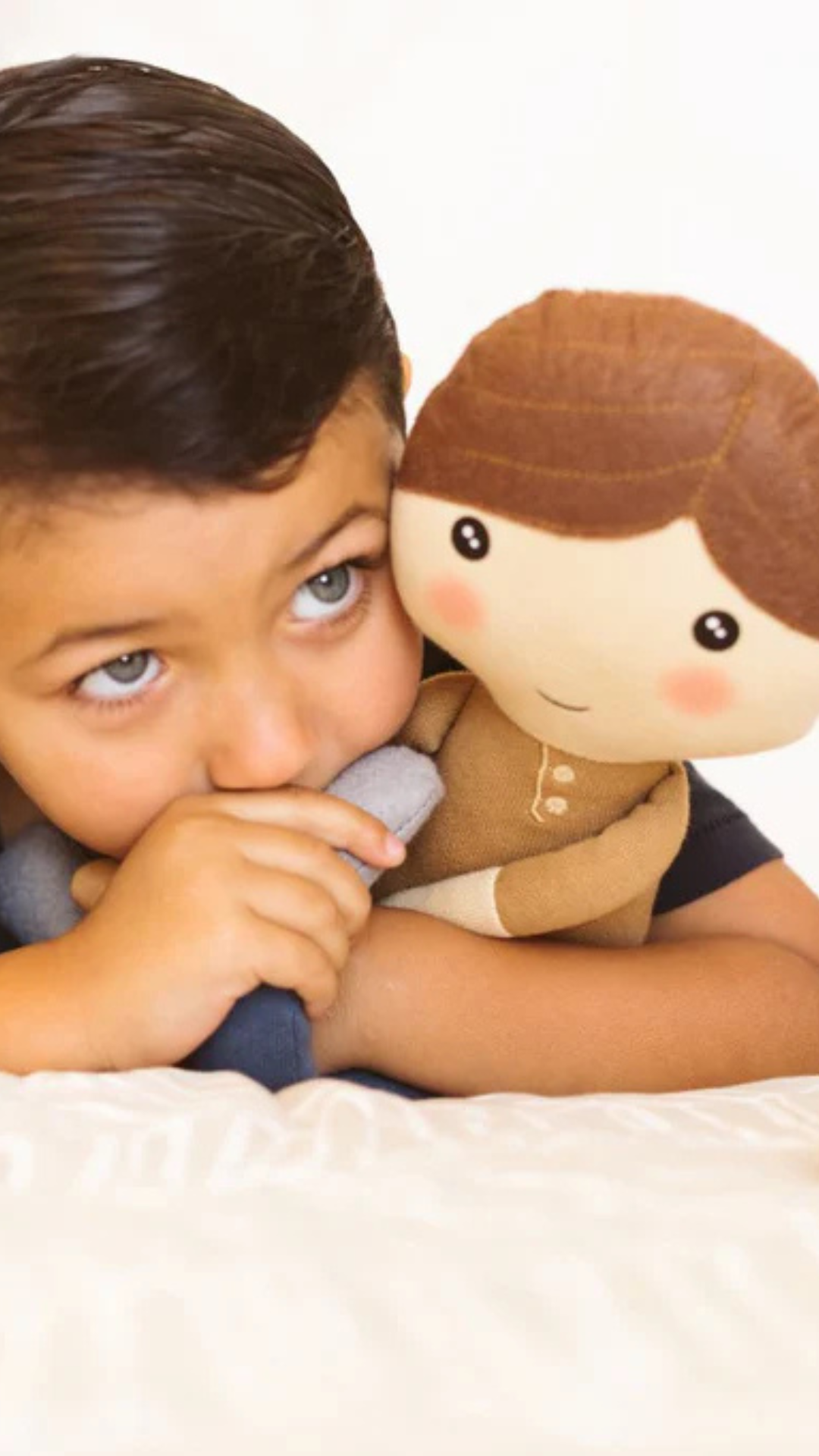 Smiling boy cuddling the soft and huggable Hope Kindness Doll, spreading kindness and love.