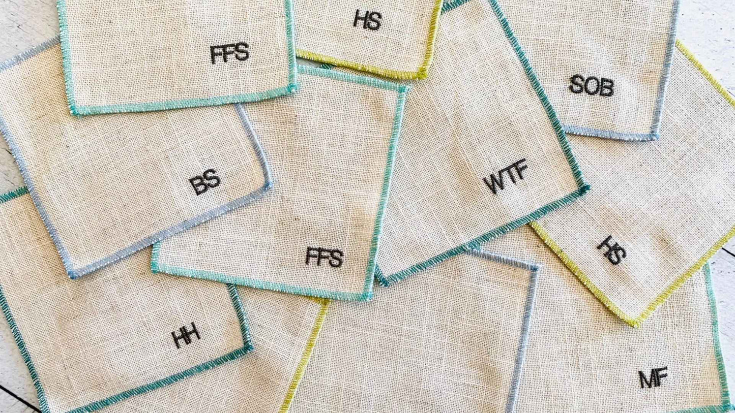 Sweary Coasters laid out to showcase their embroidered abbreviations that give a little laugh and make the perfect hostess gift